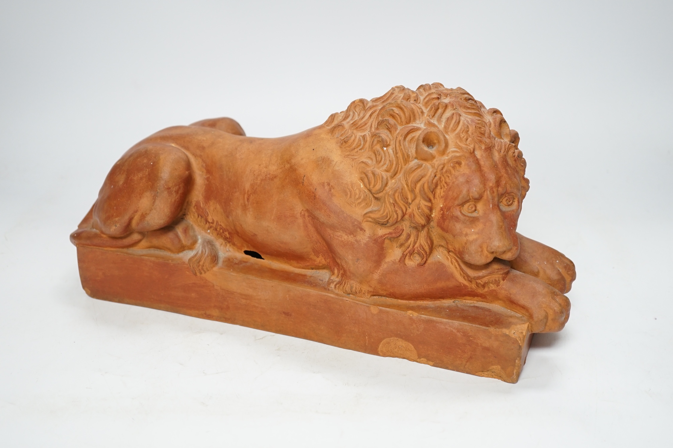 After Antonio Canova (1757-1822), a terracotta figure of a recumbent lion, 33cm. Condition - poor to fair